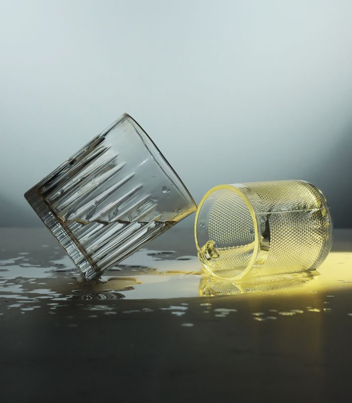 Elegant composition of overturned glasses with liquid splash and dramatic lighting.